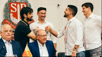 Ex-prefeito de Guarulhos filiado ao PSD, Guti (de camisa polo preta) cumprimenta o deputado estadual Caio França (PSB) durante congresso do PSB na Assembleia Legislativa de São Paulo (Alesp). Foto: Reprodução Instagram via @caiofranca_